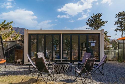 a group of chairs sitting in front of a building at Lala Land Pet Friendly Pension in Gyeongju