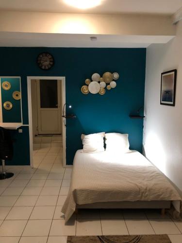 a bedroom with a blue wall with a bed at Confortable studio in Loudun
