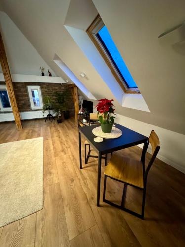 a dining room with a table and a plant on it at Apartamenty Astor - Księżycowy in Szczawno-Zdrój