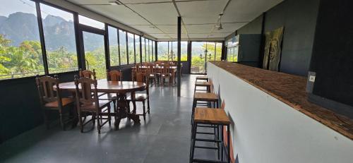 a restaurant with tables and chairs and windows at Khao Sok Horizon in Ban Bang Thong