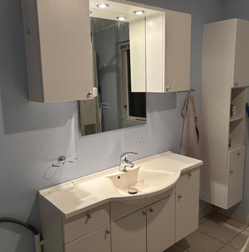 a bathroom with a sink and a mirror at Charmerende hus i idylliske Lynæs in Hundested