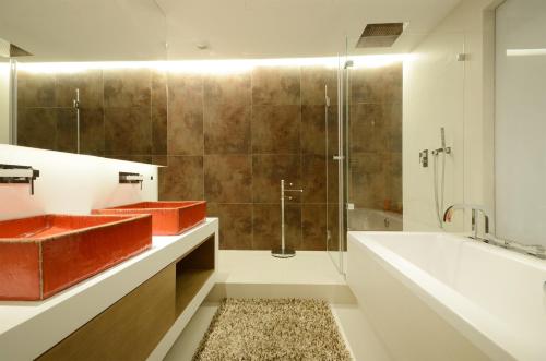a bathroom with two sinks and a tub and a shower at Dom & House - Apartamenty Sea Towers in Gdynia