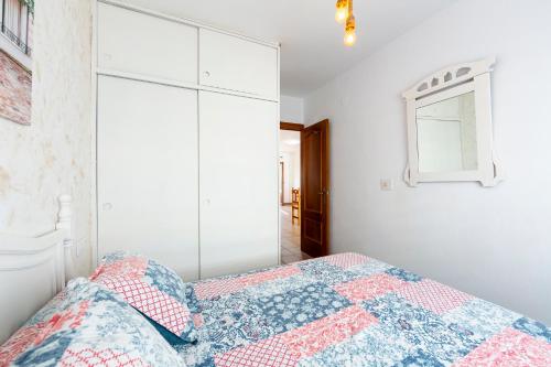 a white bedroom with a bed and a mirror at Noria 1 in El Pozo de los Frailes