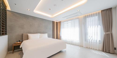 a bedroom with a white bed and a large window at The hound hotel bandalseom2 in Ansan