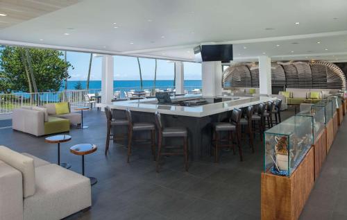 a bar in a room with a view of the ocean at Grand Naniloa Hotel, a Doubletree by Hilton in Hilo