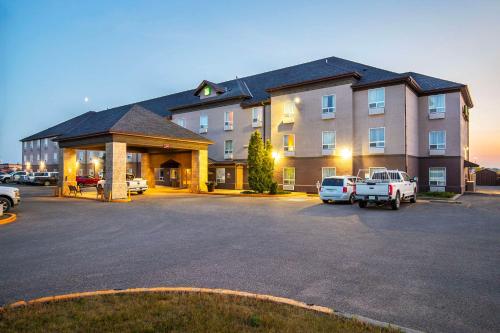 a large building with cars parked in a parking lot at Quality Inn & Suites Yorkton in Yorkton