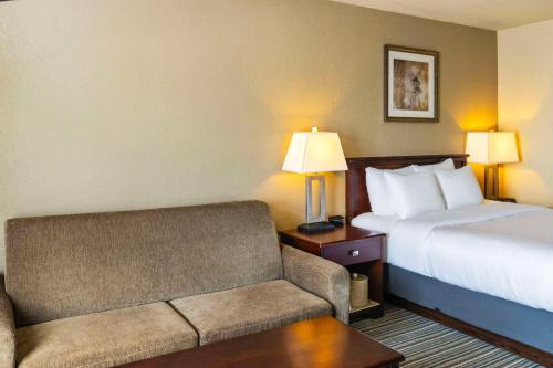a hotel room with a bed and a couch at Quality Inn & Suites Yorkton in Yorkton