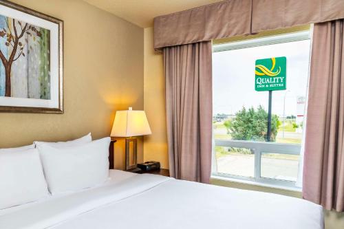 a hotel room with a bed and a window at Quality Inn & Suites Yorkton in Yorkton
