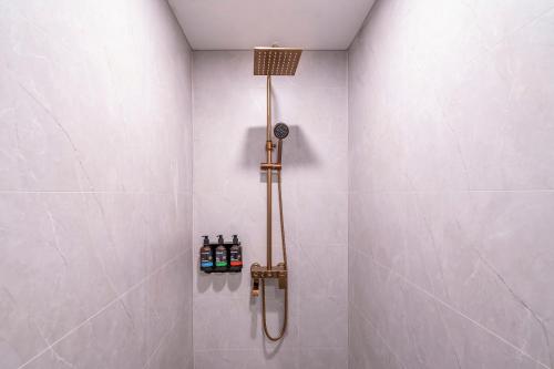 a shower in a bathroom with bottles on the wall at Dequan Luxury HotelGuomao BranchThe subway is right outside the door Coffee, fruits, snacks, a gym and a laundry room are provided for free in the lobby in Beijing