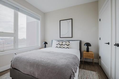 a white bedroom with a bed and a window at Blueground East Boston AC balcony nr park BOS-1130 in Boston