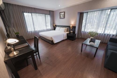 a large hotel room with a bed and a desk at La Passion Classic Hotel in Hanoi