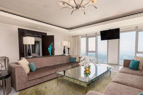 a living room with a couch and a glass table at Hilton Dubai Al Habtoor City in Dubai