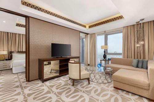a living room with a couch and a television at Hilton Dubai Al Habtoor City in Dubai