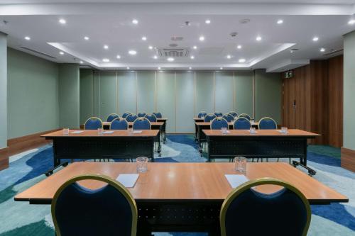 a conference room with wooden tables and chairs at Hilton Porto Alegre, Brazil in Porto Alegre