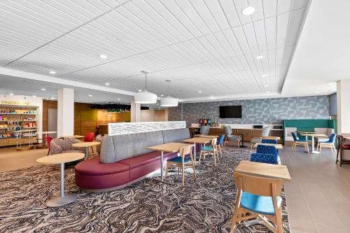 a lobby with a couch and tables and chairs at Home2 Suites By Hilton Hendersonville in Hendersonville
