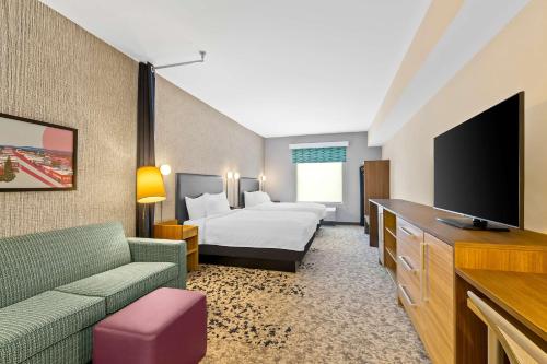 a hotel room with a bed and a flat screen tv at Home2 Suites By Hilton Hendersonville in Hendersonville