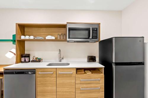 a kitchen with a stainless steel refrigerator and a microwave at Home2 Suites By Hilton Hendersonville in Hendersonville
