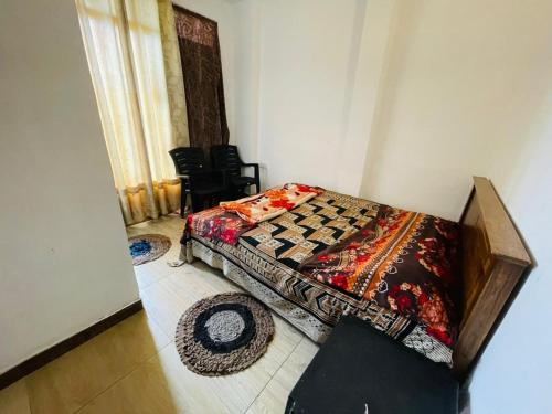 a bedroom with a bed with a quilt on it at New Eagle Best Inn in Haputale
