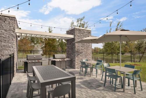 a patio with tables and chairs and umbrellas at Home2 Suites By Hilton Sanford Orlando North in Sanford