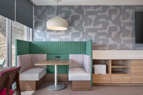 a dining room with a table and a green wall at Home2 Suites By Hilton Sanford Orlando North in Sanford