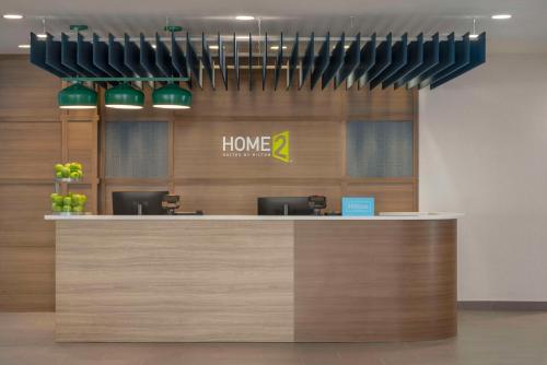 a lobby with a counter with a home sign at Home2 Suites By Hilton Sanford Orlando North in Sanford