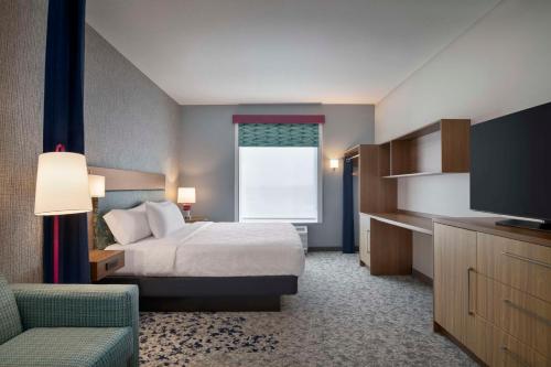a hotel room with a bed and a television at Home2 Suites By Hilton Sanford Orlando North in Sanford