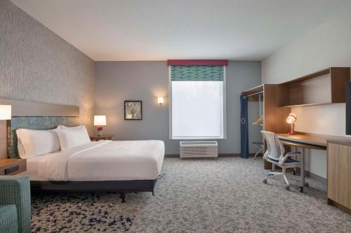 a hotel room with a bed and a desk at Home2 Suites By Hilton Sanford Orlando North in Sanford
