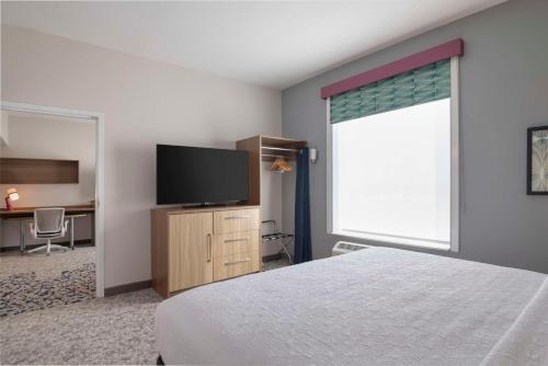 a bedroom with a bed and a flat screen tv at Home2 Suites By Hilton Sanford Orlando North in Sanford