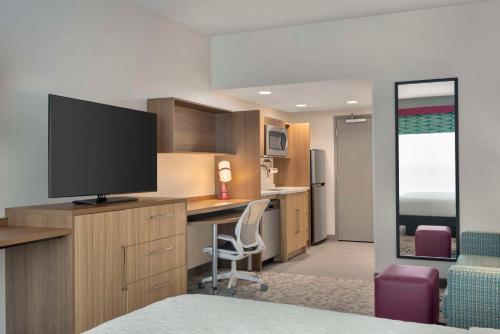 a room with a desk with a television on a desk sidx sidx sidx at Home2 Suites By Hilton Sanford Orlando North in Sanford