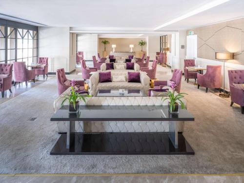 a living room with purple chairs and a couch at The Hotel Galleria Jeddah, Curio Collection by Hilton in Jeddah