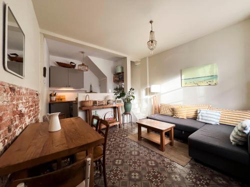 un salon avec un canapé et une table dans l'établissement charmante maison de pêcheur, à Trouville-sur-Mer