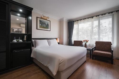 a bedroom with a large white bed and a window at La Passion Classic Hotel in Hanoi