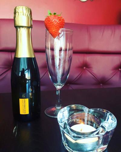 a bottle of wine and a glass with a strawberry on a table at Chieftain Hotel in Inverness