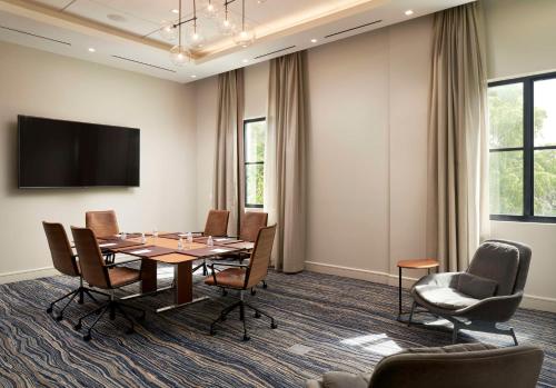 a conference room with a table and chairs and a flat screen tv at THesis Hotel Miami Coral Gables, Curio Collection by Hilton in Miami