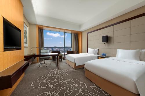 a hotel room with two beds and a television at Crowne Plaza Yichang by IHG in Yichang