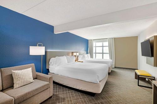 a hotel room with two beds and a couch at Comfort Inn & Suites Arlington Heights - Schaumburg in Arlington Heights