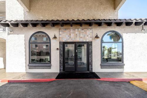 a building with a black door and two windows at MainStay Suites Moreno Valley Near March Air Reserve Base in Moreno Valley