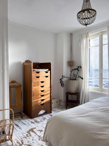 une chambre avec un lit, une commode et une fenêtre dans l'établissement charmante maison de pêcheur, à Trouville-sur-Mer