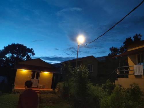 a man walking in front of a house with a street light at Into the mountain in Pokhara