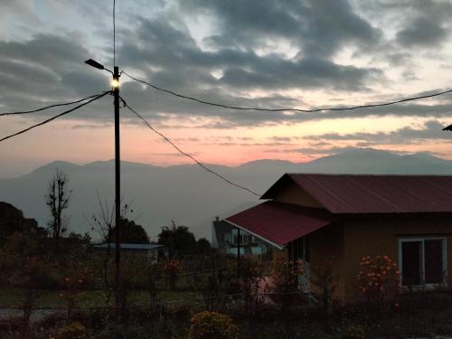 a house with a street light in front of a sunset at Into the mountain in Pokhara