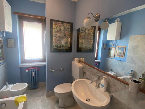 a blue bathroom with a toilet and a sink at Delizioso appartmento tra le Alpi in Prali Villa