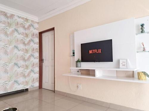 a living room with a television on a wall at C-Rane Lodge in Phalaborwa