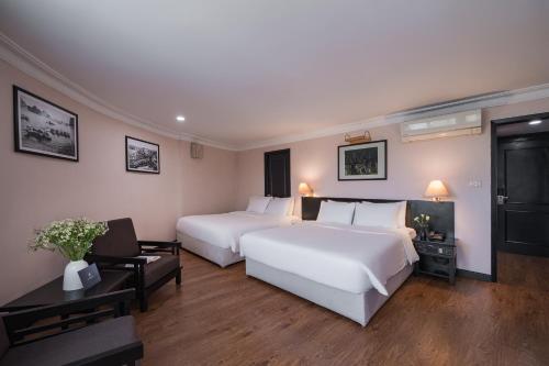 a hotel room with two beds and a television at La Passion Classic Hotel in Hanoi