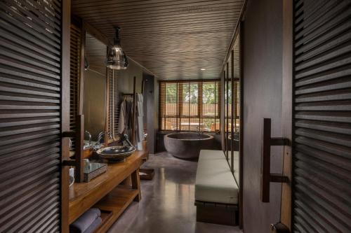 a bathroom with two sinks and a large tub at Silavadee Pool Spa Resort - SHA Extra Plus in Lamai