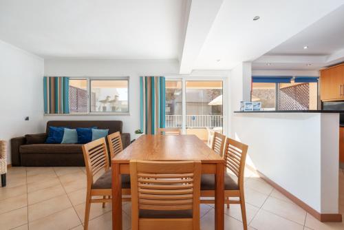 a kitchen and dining room with a table and chairs at Comfortable Duplex Apartment with 2 bedrooms & 2 terraces 200 m away from the Ocean in Porches