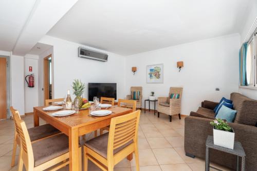 a dining room and living room with a table and chairs at Comfortable Duplex Apartment with 2 bedrooms & 2 terraces 200 m away from the Ocean in Porches
