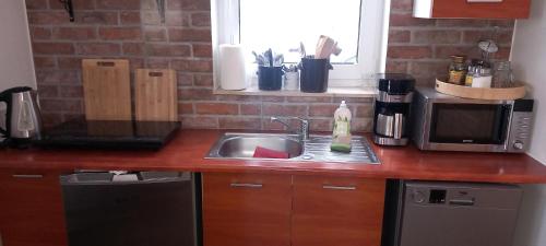 a kitchen counter with a sink and a microwave at Domki Obłazówka nad Białką in Nowa Biała