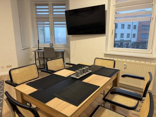 a dining room with a table and chairs and a television at Gemütliche Wohnung direkt am Bahnhof perfekte Lage in Bitterfeld