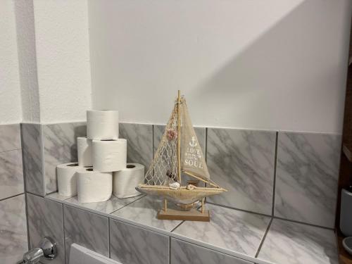 a shelf with a small sail boat and toilet paper at Gemütliche Wohnung direkt am Bahnhof perfekte Lage in Bitterfeld