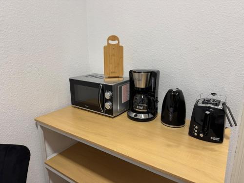 a counter with a microwave and appliances on it at Gemütliche Wohnung direkt am Bahnhof perfekte Lage in Bitterfeld